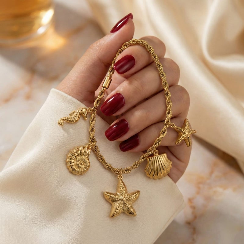 انسيال ذهبي أنيق مصنوع من الستانلس ستيل المقاوم للصدأ، بسلسلة مجدولة راقية تزينها دلايات أصداف ونجوم بحر بتفاصيل بارزة، مع قفل قابل للتعديل ليناسبكِ. - Image 3